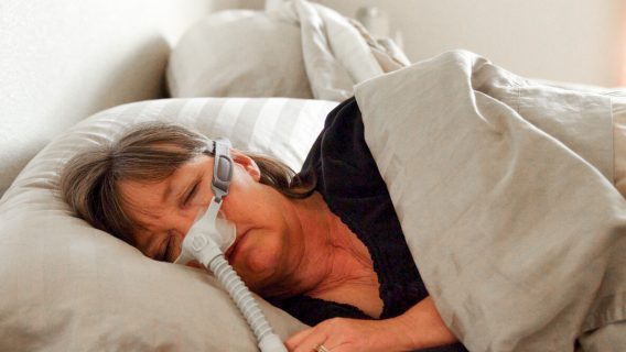Woman asleep using CPAP machine
