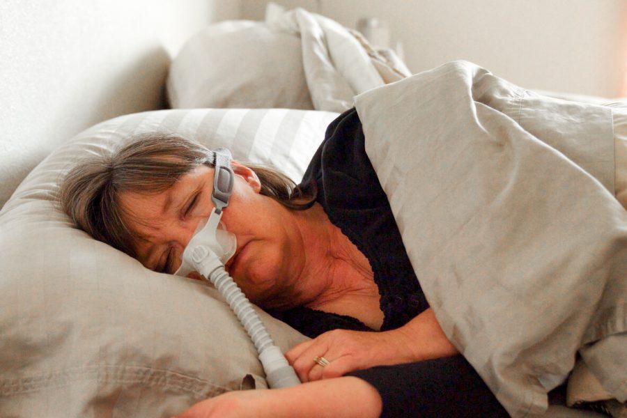 Woman asleep using CPAP machine