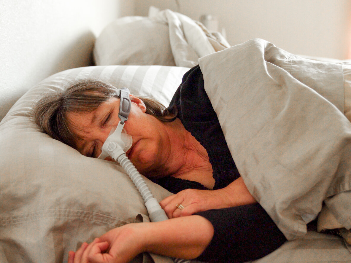 Woman asleep using CPAP machine