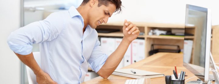Man with back pain sitting at his desk