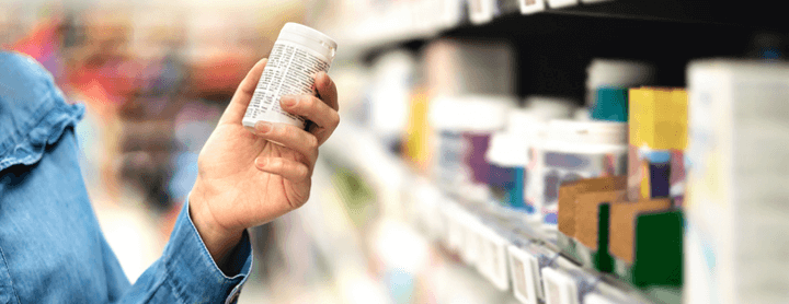 Customer in pharmacy holding medicine bottle