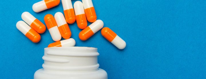 Pills spill out of bottle onto surface