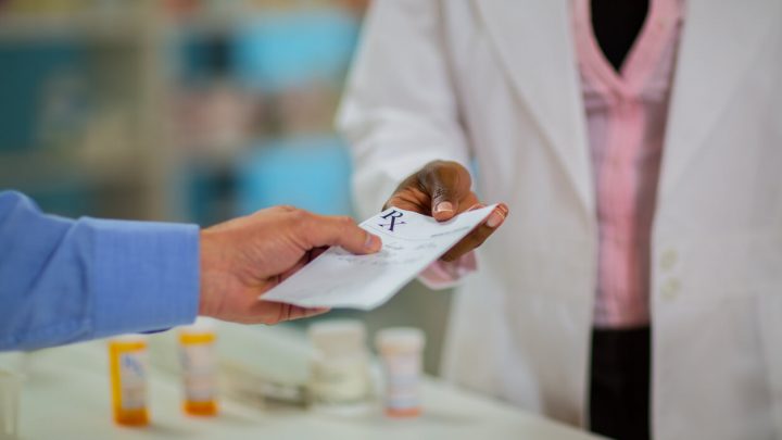 Patient handing a prescription to a pharmacist
