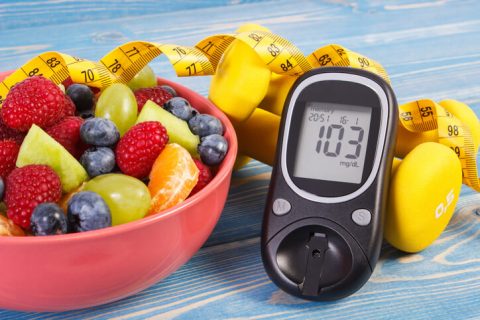 Fruit salad, glucose meter, centimeter and dumbbells, diabetes, healthy lifestyle and nutrition concept