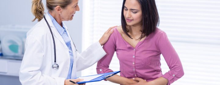 Woman discussing abdominal pain with doctor