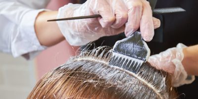 Woman using hair dye on another woman's hair
