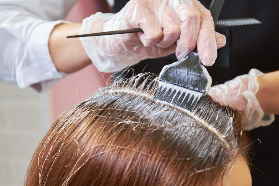 Woman using hair dye on another woman's hair