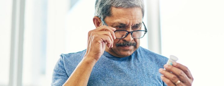 Man inspecting label on pill bottle