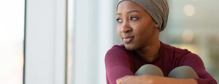 Woman in head scarf staring out window