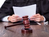 Judge holding document with gavel in front