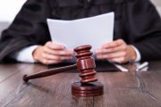Judge holding document with gavel in front