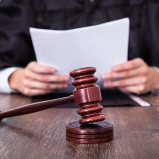 Judge holding document with gavel in front