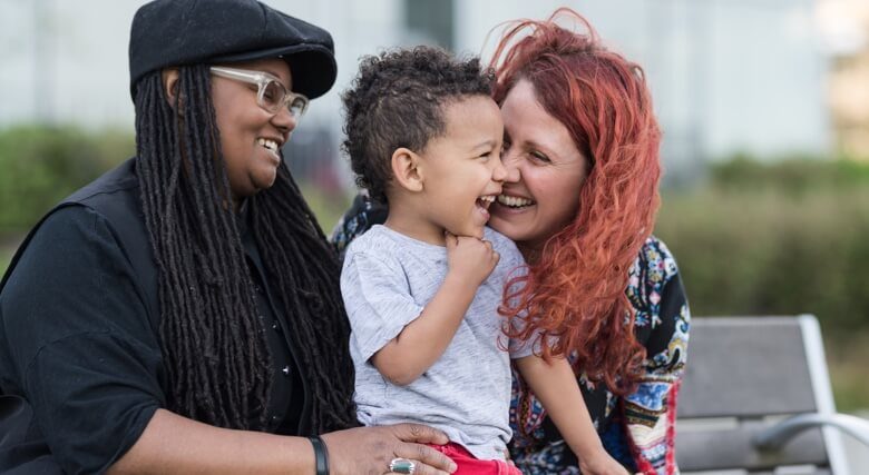 Two mothers holding their son on their laps