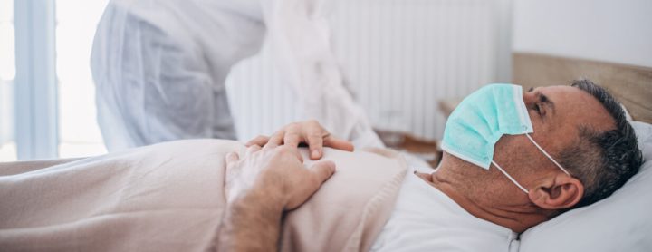 Man with flu smyptoms in hospital bed