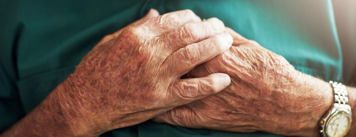 Elderly man in pain with his hands on his chest