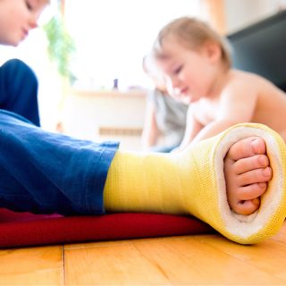 Boy with broken leg with his brother playing