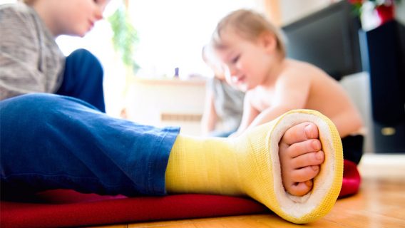 Boy with broken leg with his brother playing