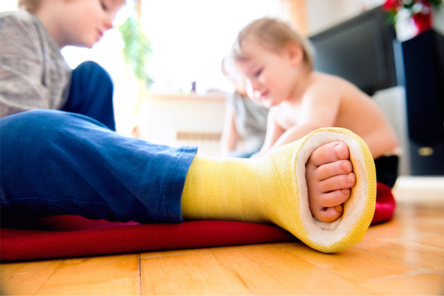 Boy with broken leg with his brother playing