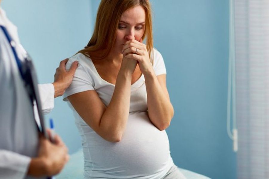 worried pregnant woman in a doctors office