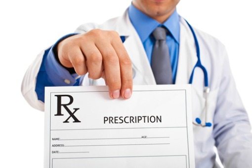 doctor holding up a prescription sheet