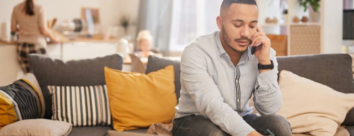 Man talking on phone while sitting on couch