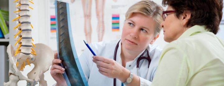 Doctor showing a woman an x-ray of her spine