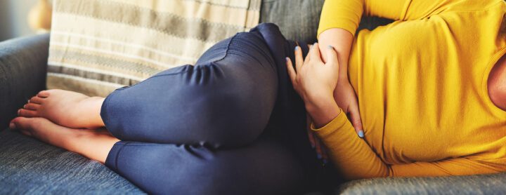 Woman with stomach pain on couch