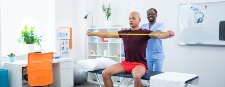 Physical therapist assisting his patient with exercises