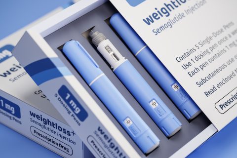 Box of semaglutide weight loss injection pens with five blue single-dose pens, one shown with needle exposed.