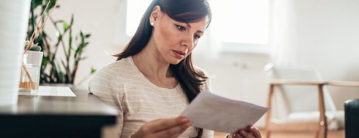 Woman with a disappointed look on her face reading a letter