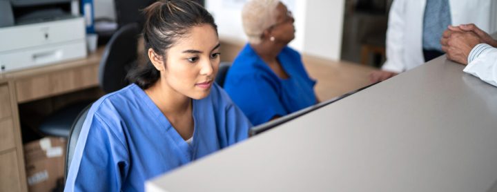 Receptionist at hospital setting at front desk
