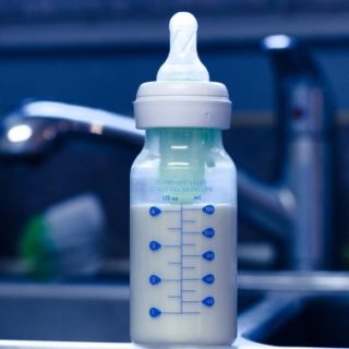 Baby bottle with formula on kitchen sink
