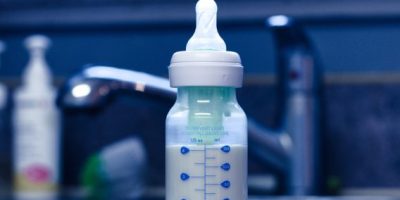 Baby bottle with formula on kitchen sink