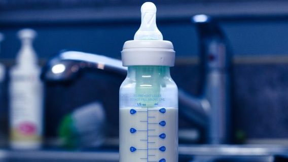 Baby bottle with formula on kitchen sink