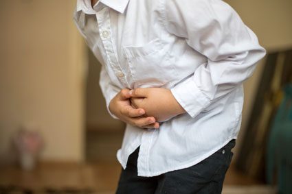 Child holding stomach in pain