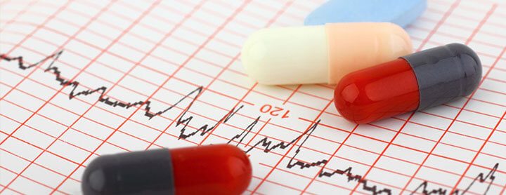 Pills laid out on paper showing heart activity readings