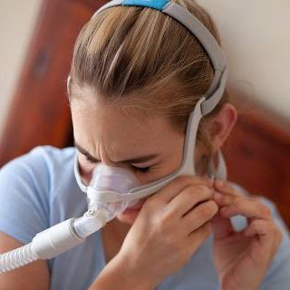 Girl putting on CPAP mask