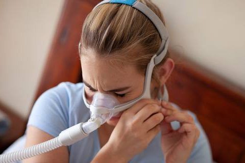Girl putting on CPAP mask