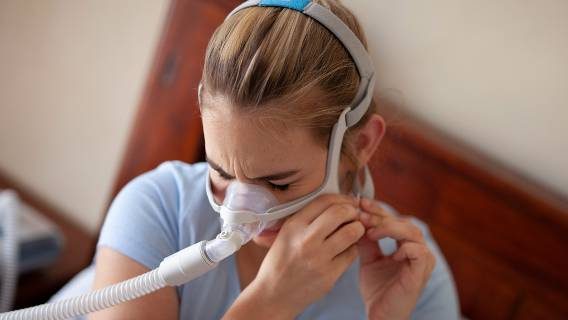 Girl putting on CPAP mask