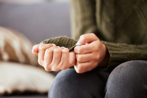 Woman sitting on a sofa and feeling anxious.