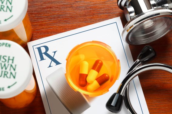 Pills, prescription pad and stethoscope