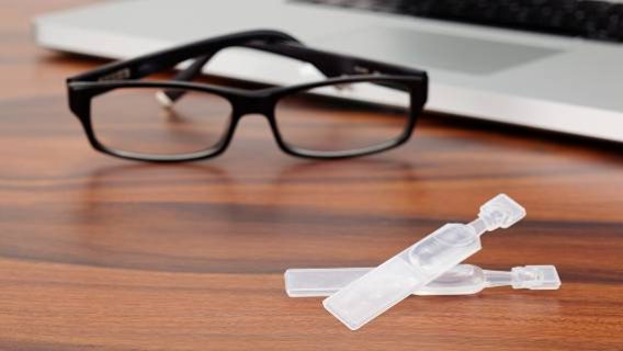 Dry eye drops, glasses and laptop