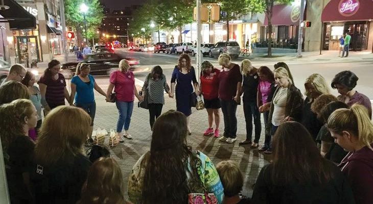 Women hold hands in circle