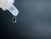 Eye drop closeup on black background