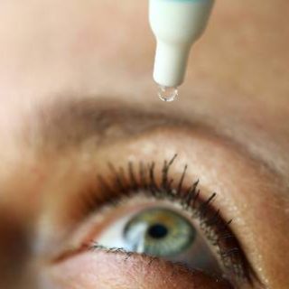 Woman putting drops in eye