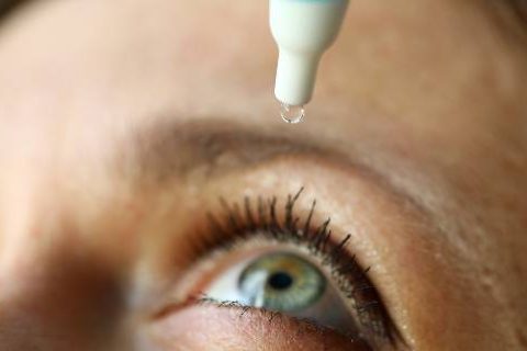Woman putting drops in eye