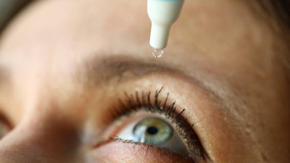 Woman putting drops in eye