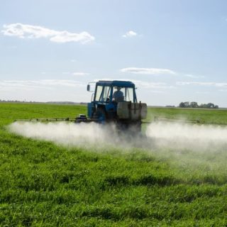 Farmer spraying weed killer with tractor