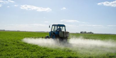 Farmer spraying weed killer with tractor