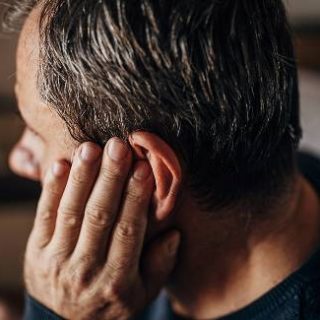 Man with hearing loss and hand to ear